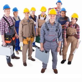 Large team of diverse artisans standing grouped together with their tools and hardhats lead by a handsome smiling foreman  high angle isolated on white